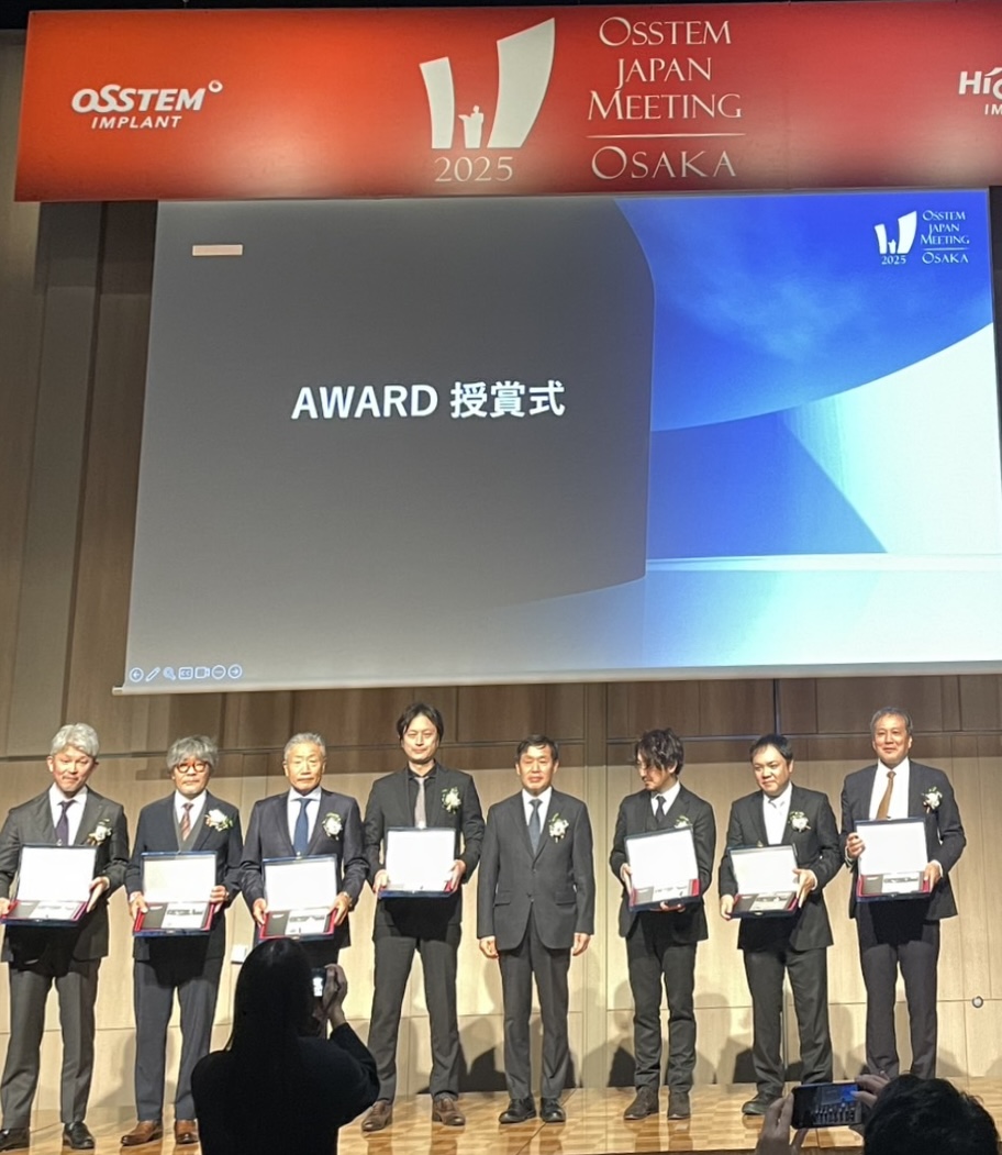 Osstem Japan Meeting 2025 Osakaでの表彰式。金山健夫先生を含む受賞者が壇上に立つ様子
